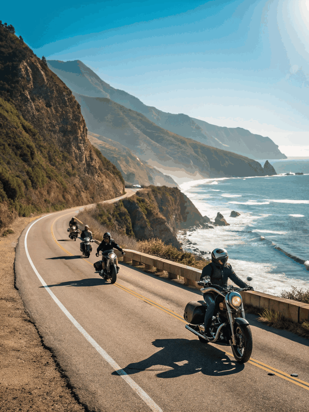 Group of riders cruising along a scenic coastal highway at sunrise